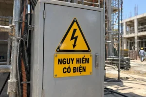 Biển cảnh báo nguy hiểm có điện: tam giác vàng tia chớp và biển chữ nhật vàng "Nguy hiểm có điện" gắn trên cửa tủ điện ở công trường