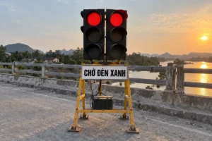 Hai bộ đèn tín hiệu tạm thời trên khung vàng chữ A, bảng trắng chữ Chờ đèn xanh gắn bên dưới, đặt cạnh lan can cầu
